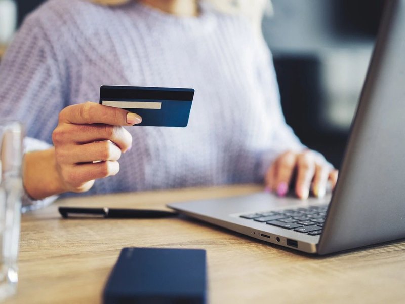 Person using a laptop to pay online by card - Quick and easy financing with approved credit via Synchrony from Carpet Plus in the Worthington, MN area
